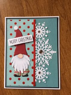 a handmade christmas card with snowflakes and a gnome's hat on it