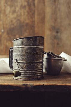 an old tin can sitting on top of a wooden table