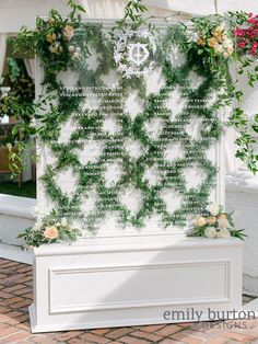 a wedding ceremony sign with greenery and flowers