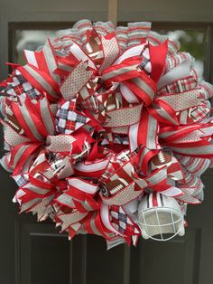 a football wreath is hanging on the front door with red, white and gray ribbons