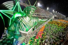 the statue of liberty is surrounded by hundreds of green plants and people in an arena