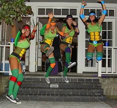 four women dressed in teenage mutant costumes jumping into the air