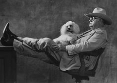 a man sitting in an office chair holding a dog