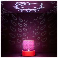 a hello kitty lamp sitting on top of a red table next to a purple wall