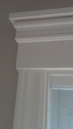 the corner of a room with white paint and molding on the wall above it