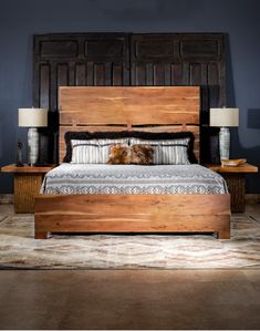 a bed with wooden headboard and foot board in a room that has blue walls