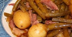 a blue and white plate topped with potatoes and green beans