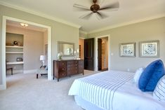 a bedroom with a bed, dresser and ceiling fan in the middle of the room