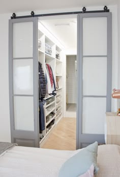 an open closet with sliding doors leading to the bedroom