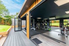 a home gym with lots of equipment in the back yard and large sliding glass doors