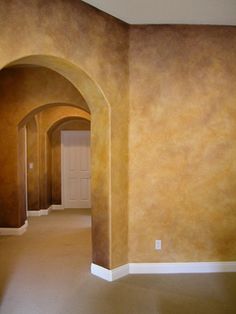 an empty room with arches painted on the walls and carpeted flooring in it