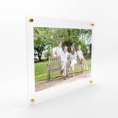 a family sitting on a park bench in the middle of a photo frame with gold studding