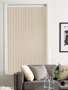 a living room with a couch, coffee table and window blinds in shades of beige