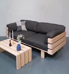 a living room with a black couch and coffee table next to it on hard wood flooring