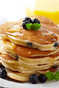 a stack of pancakes with blueberries and syrup