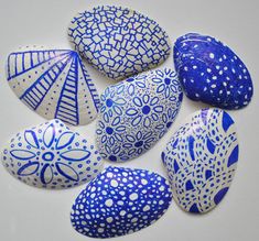 blue and white painted rocks with designs on them