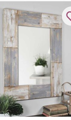 a mirror that is sitting on top of a table next to a potted plant