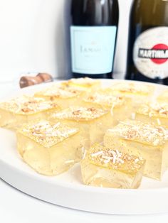 several pieces of food on a white plate next to bottles of wine and chocolates