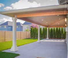 an outdoor covered patio with grass and trees