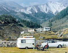 two people are camping in the mountains with their rv and car next to each other