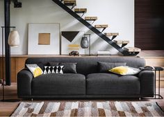 a living room filled with furniture next to a stair case