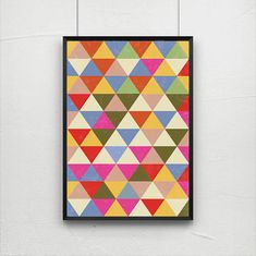 a colorful poster hanging on the wall next to a white wall with a black frame