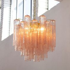 a chandelier hanging from a ceiling in a room with white walls and windows