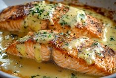 two salmon fillets with sauce in a white bowl