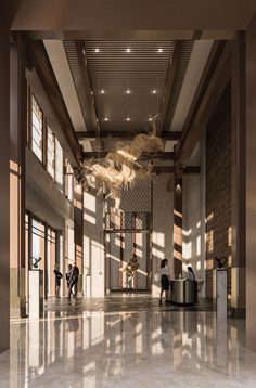 people are standing in the lobby of an office building with large windows and chandeliers hanging from the ceiling