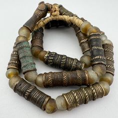 A strand of Old African TIV Bronze trade beads - late 1800's to early 1900's. Nicely worn old beads with a rich patina.  Traditionally worn in the hair Separated by traditional recycled glass beads. 14 Tiv beads  29" of beads 32" length 14 to 20mm diameter 35 to 48mm long 8-9mm hole Vintage Bronze Beaded Necklaces With Round Beads, Vintage Style Wooden Beads For Jewelry Making, Large Bronze Round Beads, Vintage Bronze Beaded Necklaces With Large Beads, Vintage Bronze Beaded Necklace With Large Beads, Artisan Bronze Beaded Necklaces With Large Beads, Artisan Bronze Beaded Necklaces With Polished Beads, Bronze Artisan Beaded Necklace With Large Beads, Artisan Beaded Necklaces With Large Bronze Beads