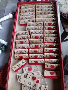 a red box filled with lots of scrabbles and hearts on top of it