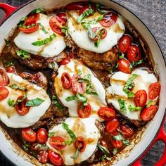 a pan filled with meat covered in sauce and tomatoes