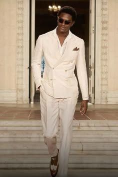 a man in a white suit and sunglasses walking down the runway at balh lauren