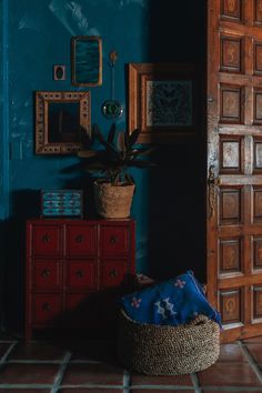 a room with blue walls and a basket on the floor in front of it, next to a wooden door