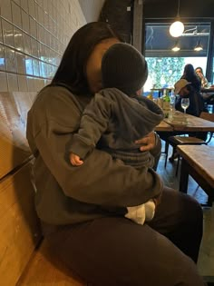 a woman sitting on a bench holding a child