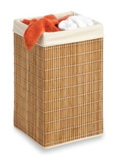 a wicker laundry hamper with an orange towel on the top and white towels in it