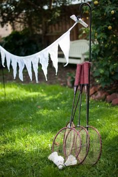 two tennis racquets, rackets and balls are on the grass outside