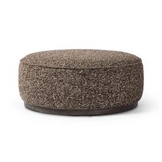 a round ottoman that is made out of wool