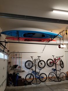 a garage with bikes and kayaks hanging from the ceiling