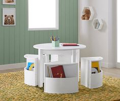 a white table with two storage bins underneath it and a teddy bear on the wall