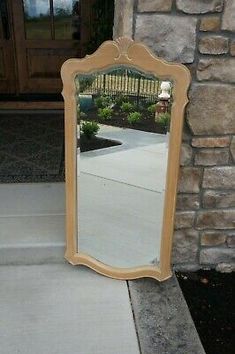 a mirror sitting on top of a sidewalk next to a brick building with a door