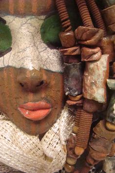 a woman's face is covered in clay and other items that are on display