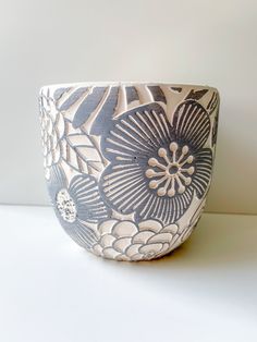 a blue and white flower pot sitting on top of a table next to a wall