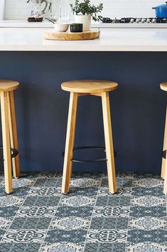 three wooden stools sitting in front of a counter