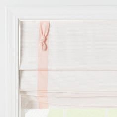 a white window with pink ribbon hanging from it's side