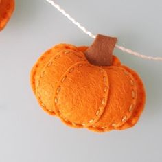 an orange felt pumpkin hanging from a string