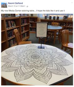 a table with an intricate design on it in front of a library full of books