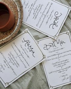 three cards with writing on them sitting next to a cup and saucer filled with liquid