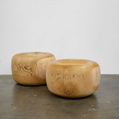 two wooden stools sitting on top of a cement floor