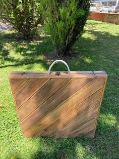 an old wooden suitcase sitting in the grass